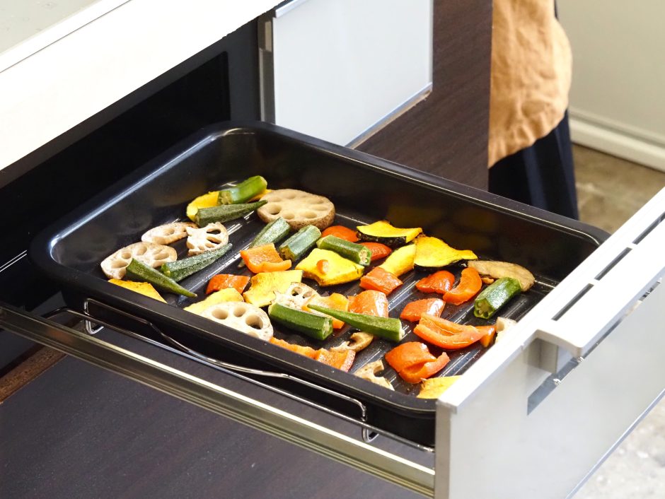 砕いた野菜を、三菱IHクッキングヒーター「CROSS+TOPシリーズ」でグリル加熱している様子